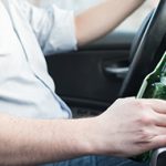 Man driving car and drinking alcohol
